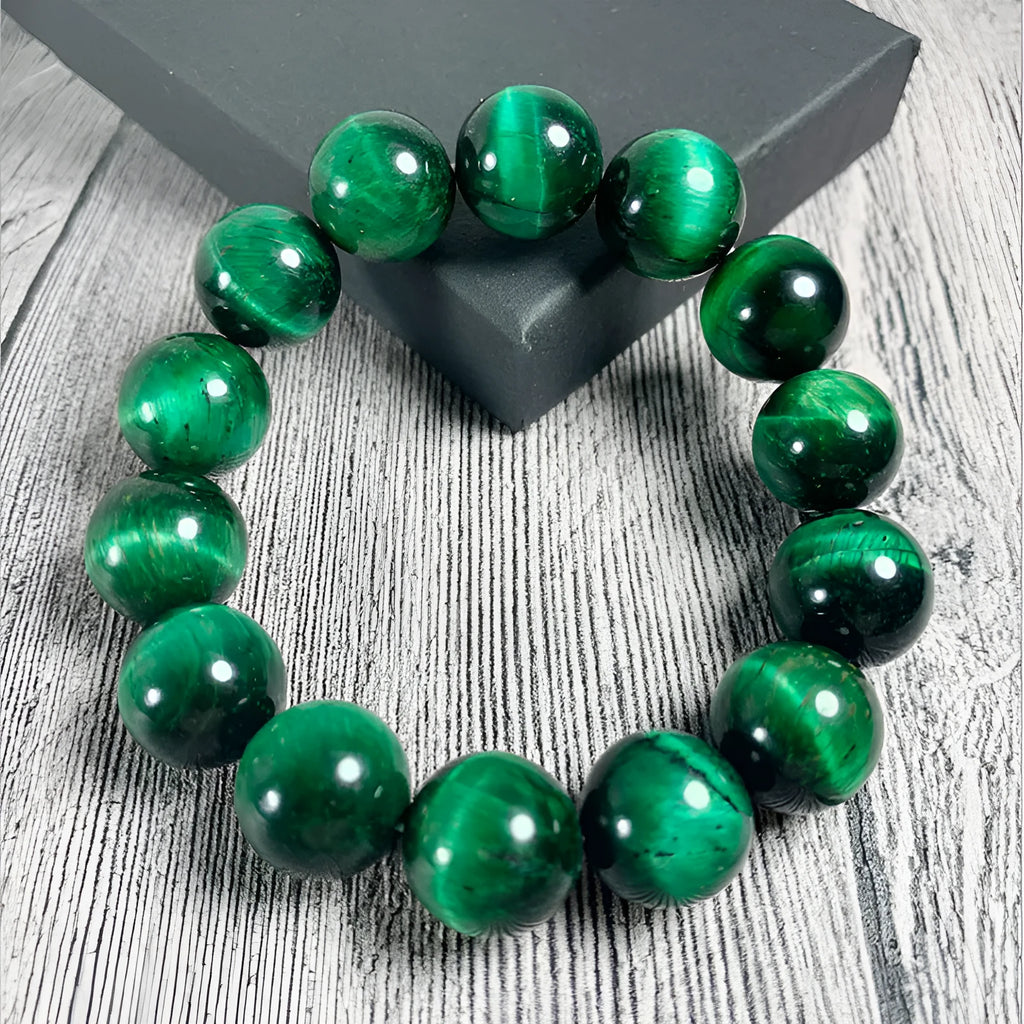Green polished Tiger Eye stone bracelet with geometry beads on a wrist.