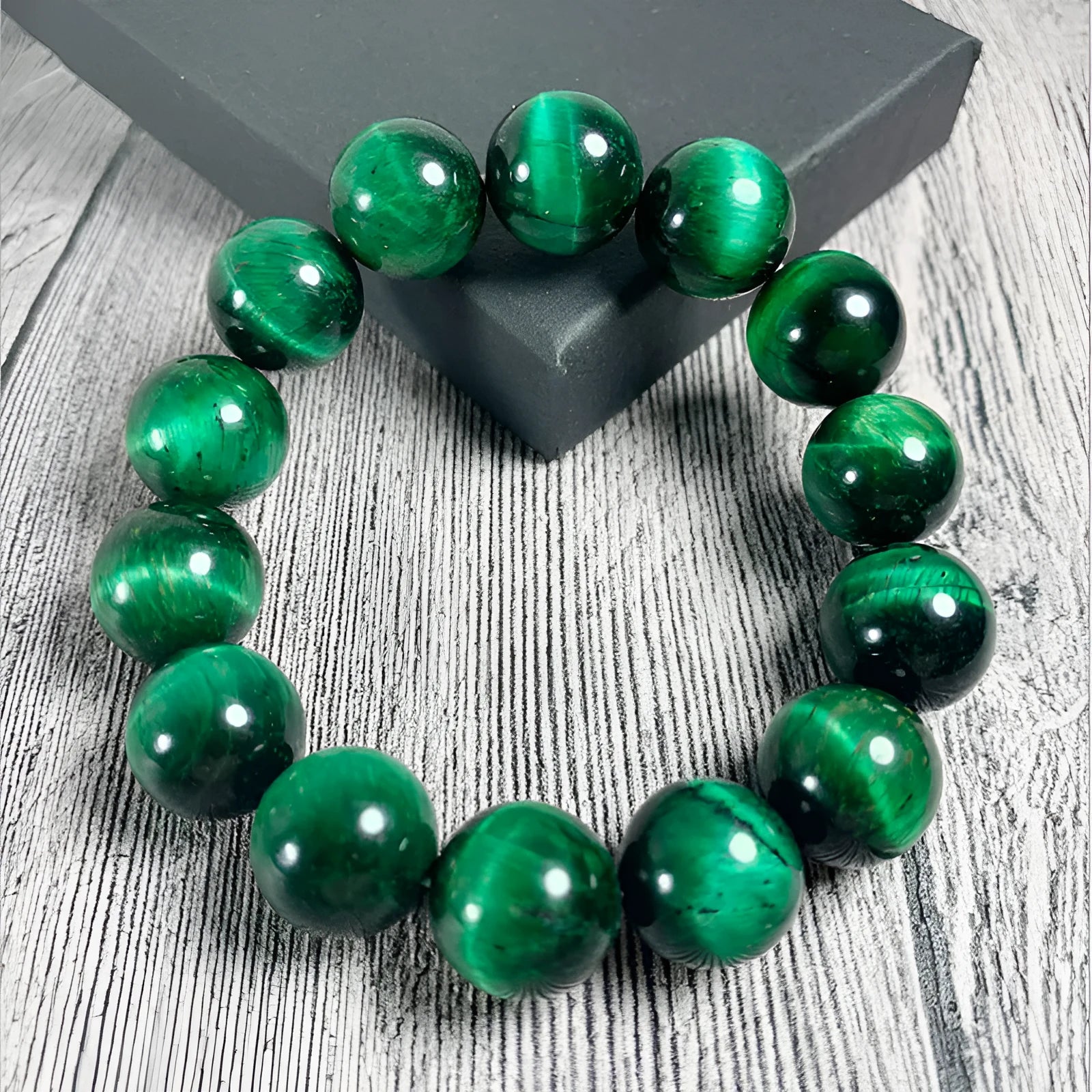 Green polished Tiger Eye stone bracelet with geometry beads on a wrist.