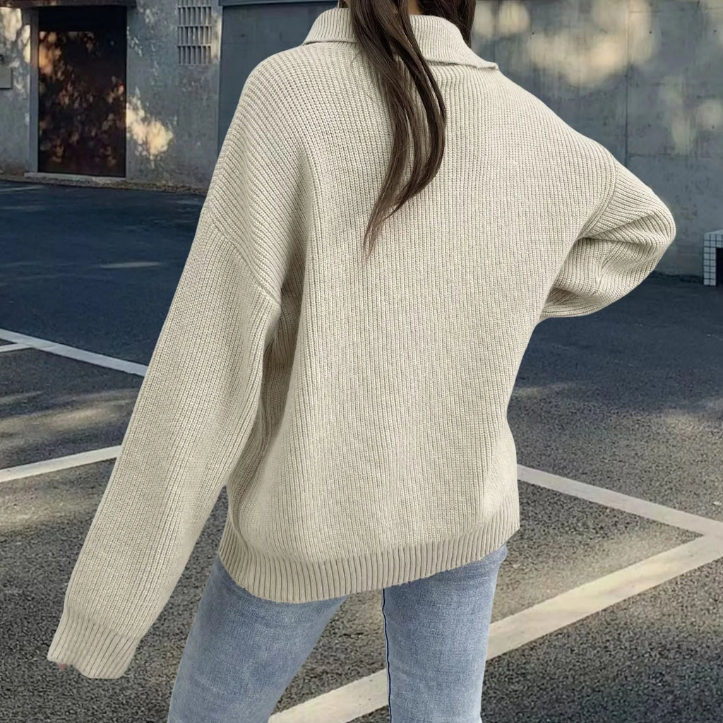 Woman wearing a light khaki retro pullover sweater with loose lapels, an oblique zip, and a text print.