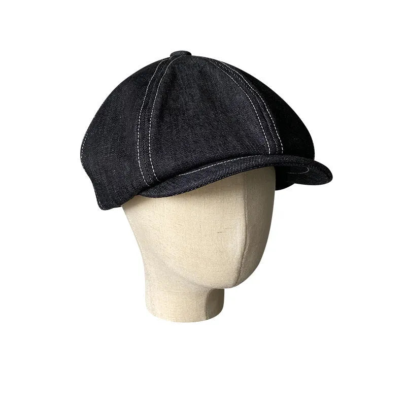 Black cotton beret with an octagonal cap style on a neutral background.