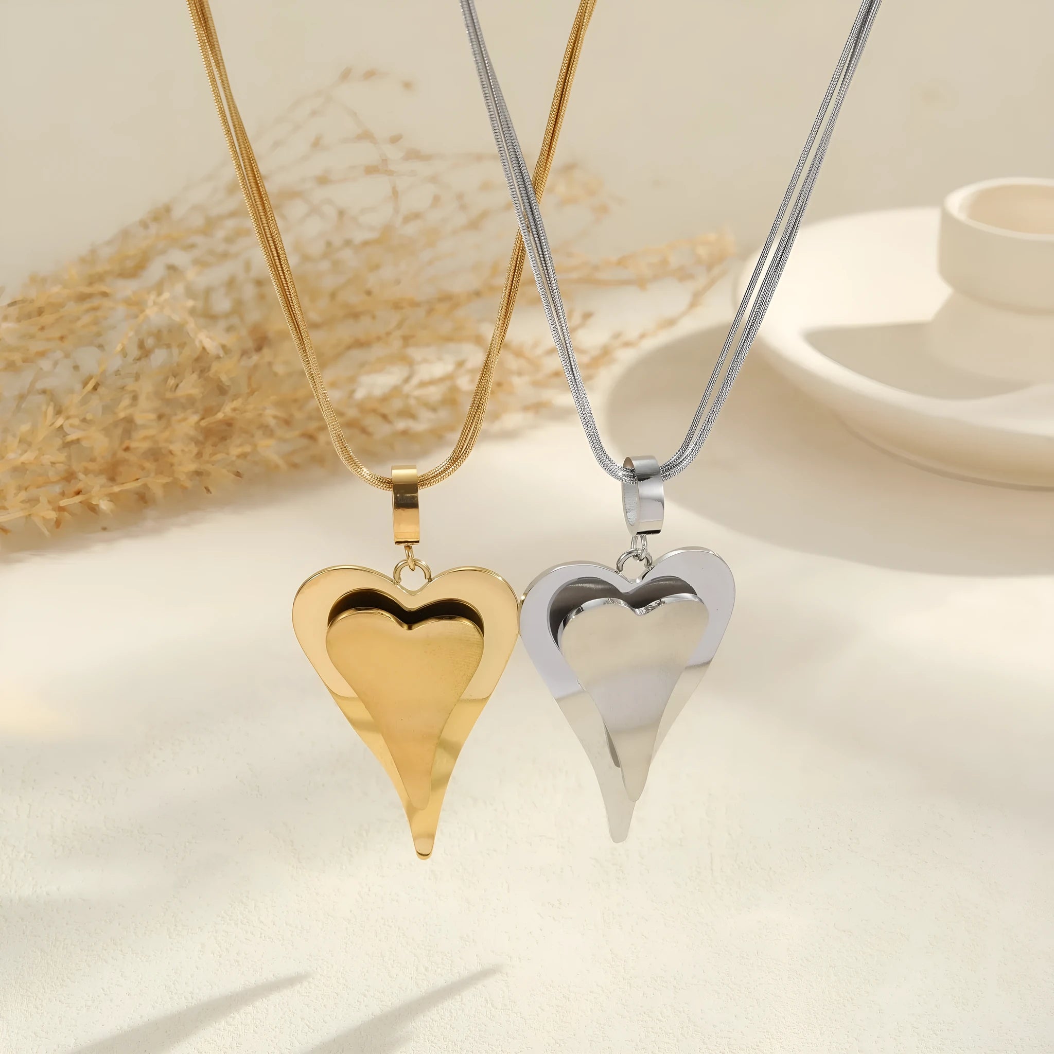 Stainless steel women's necklace with geometric double heart pendant and snake bones chain in gold or steel finish