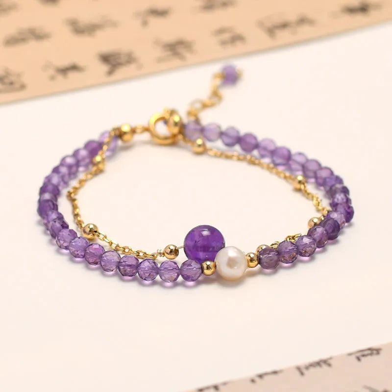 Close-up of a Chinese style women's bracelet with diamond-shaped amethyst crystal beads and an electroplated finish.