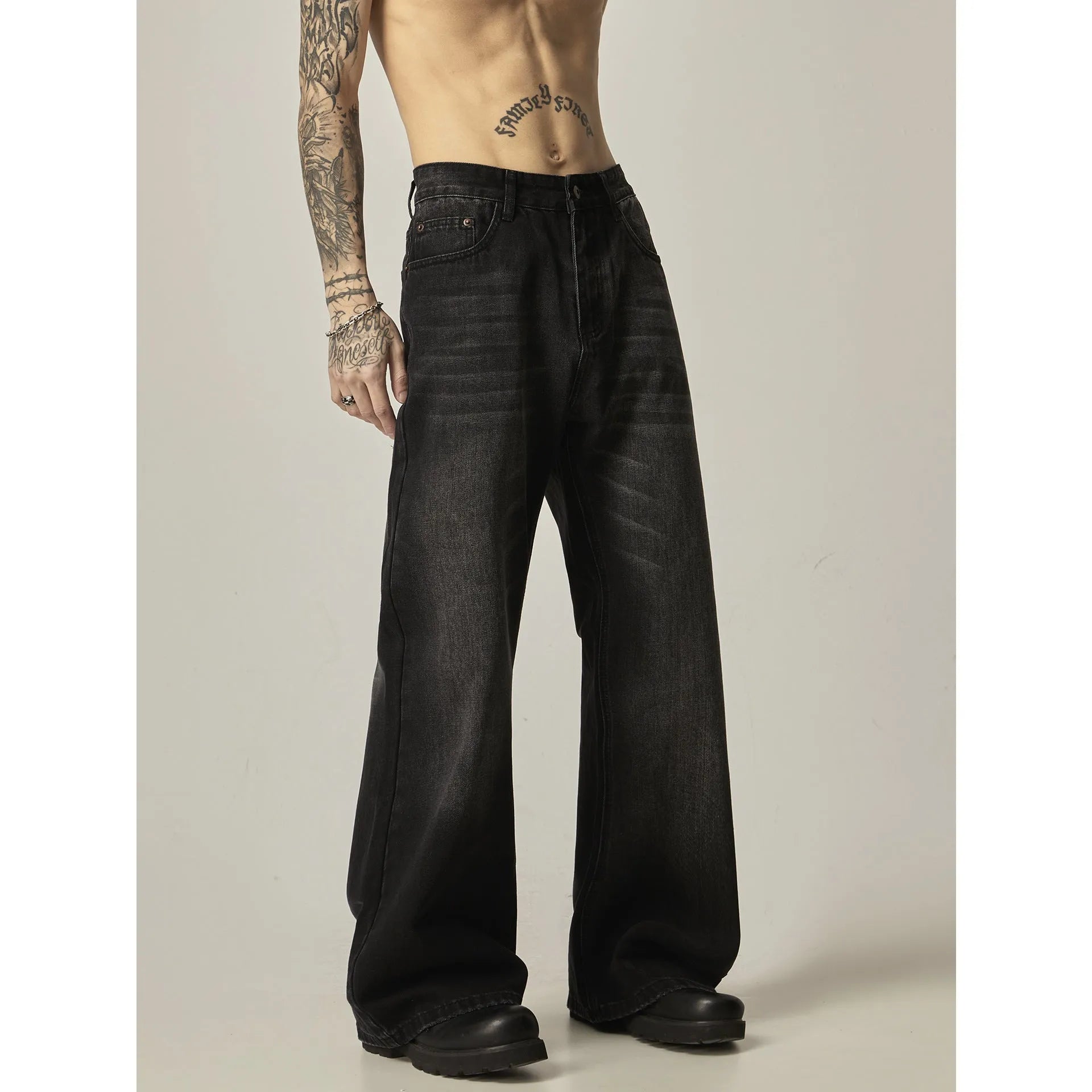 Black loose straight leg retro jeans on a hanger, showing zipper fly detail.