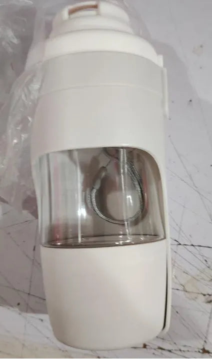 Grey folding travel dog water bottle with attached lanyard and separate food container, shown next to a backpack.