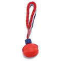 Red rubber dog ball with rope attachment for tug of war and teeth cleaning