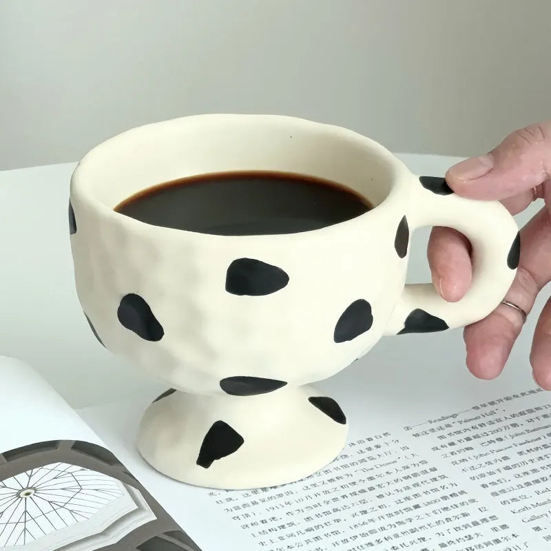 Hand-pinched irregular ceramic mug in a solid colour, shown from the side to display its unique shape.