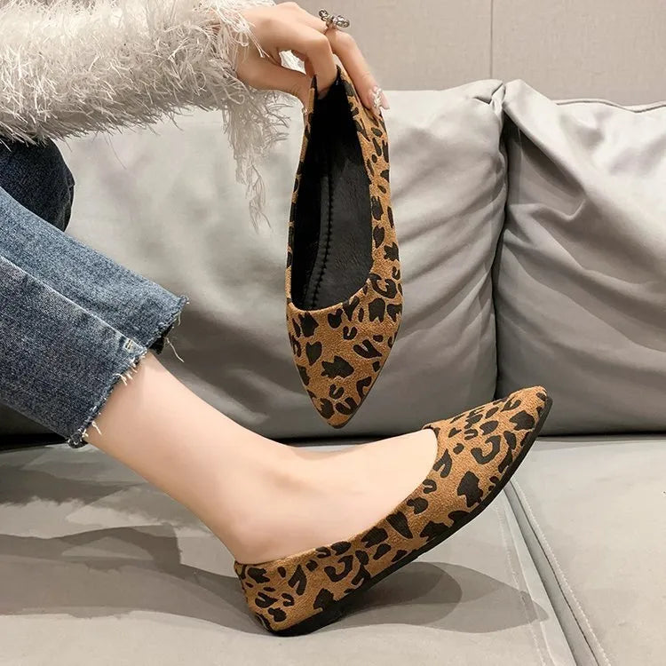 Women's leopard print flat pointed toe pumps with low heel on a rubber sole.