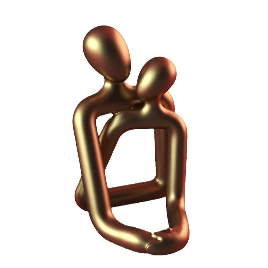 Modern couple resin statue in milky white or gold on a wooden surface.