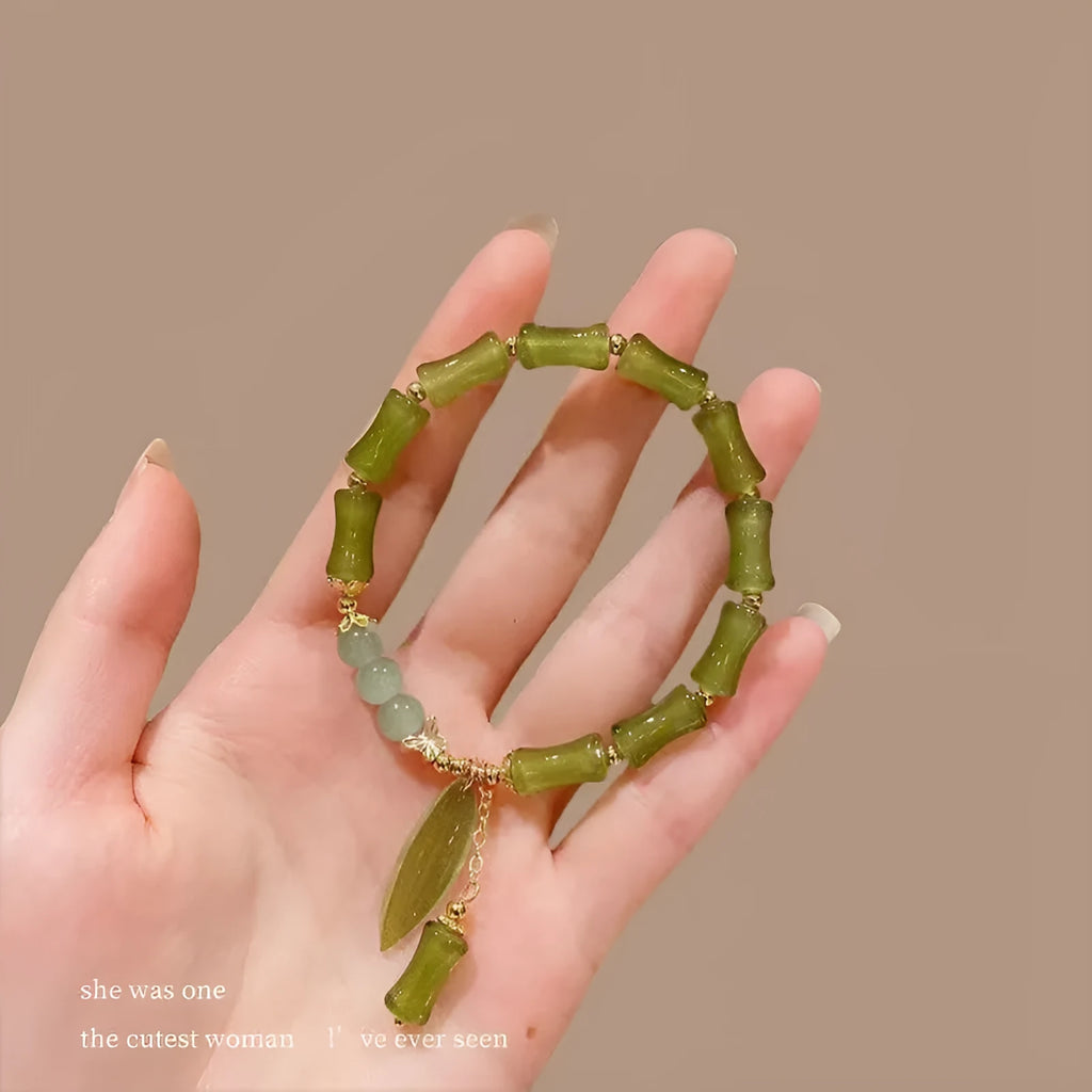 Chinese style handmade glass bead bracelet with bamboo joint elements on a white background.