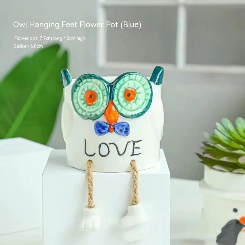 Ceramic cartoon-style hanging foot flowerpot for succulent plants on a desktop.
