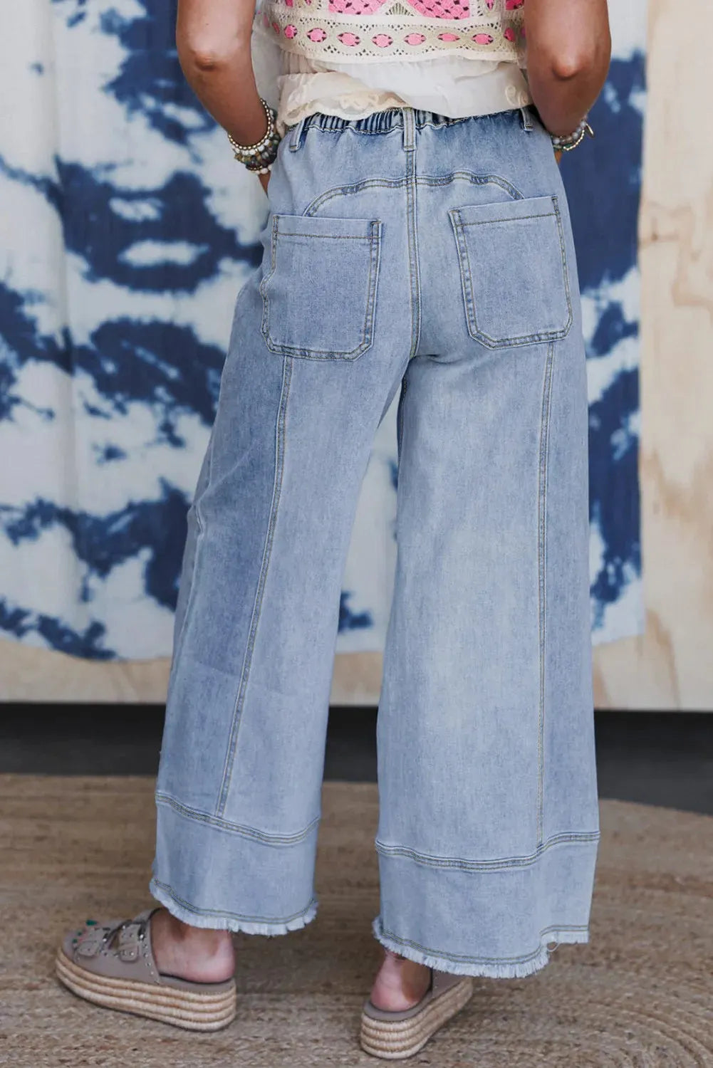 Beau blue wide leg denim trousers with a drawstring waist and raw hem detailing.