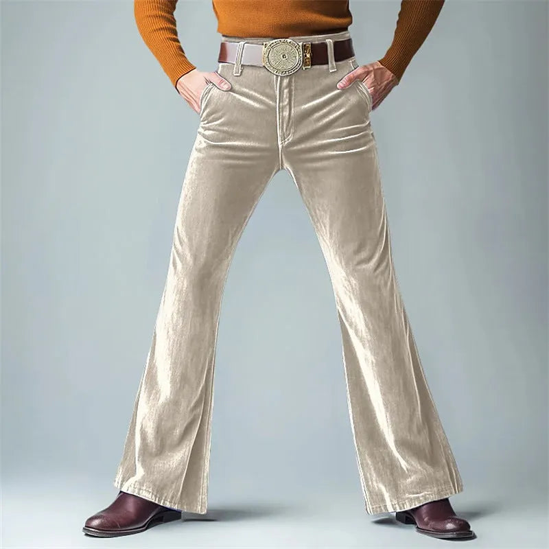 Man wearing gold velvet slim flared suit trousers in dark red for a formal banquet setting.
