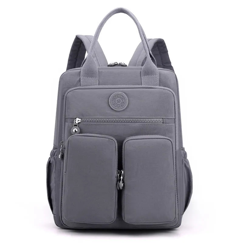 Women's large waterproof nylon travel backpack in lotus root purple showing internal laptop and camera compartments.