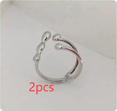 Brass opening ring with circle and sphere design in gold finish on finger