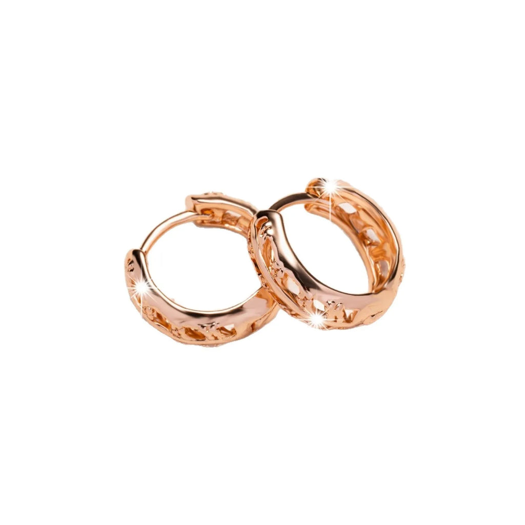 Copper hollowed-out leaf and heart shaped earrings with rose gold finish showing geometric patterns