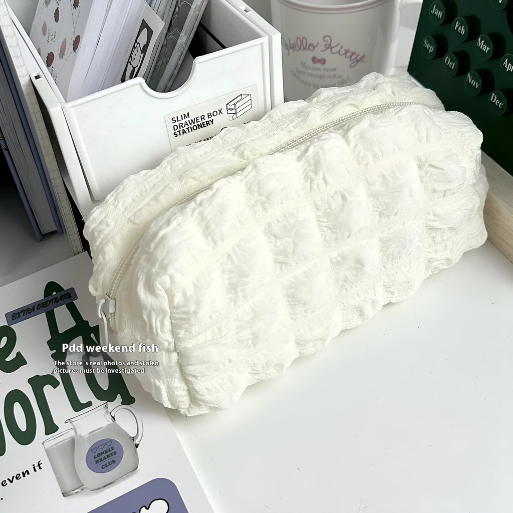Beige and black cream puff style fabric pencil case made from polyester for pen organisation.