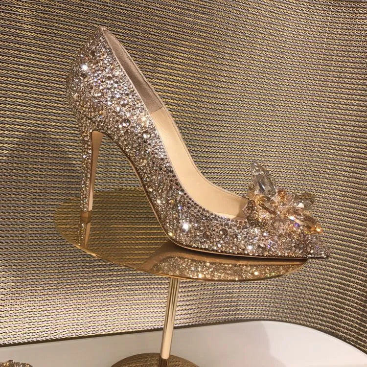 Women's gold pointed toe stiletto heels decorated with rhinestones and a bow