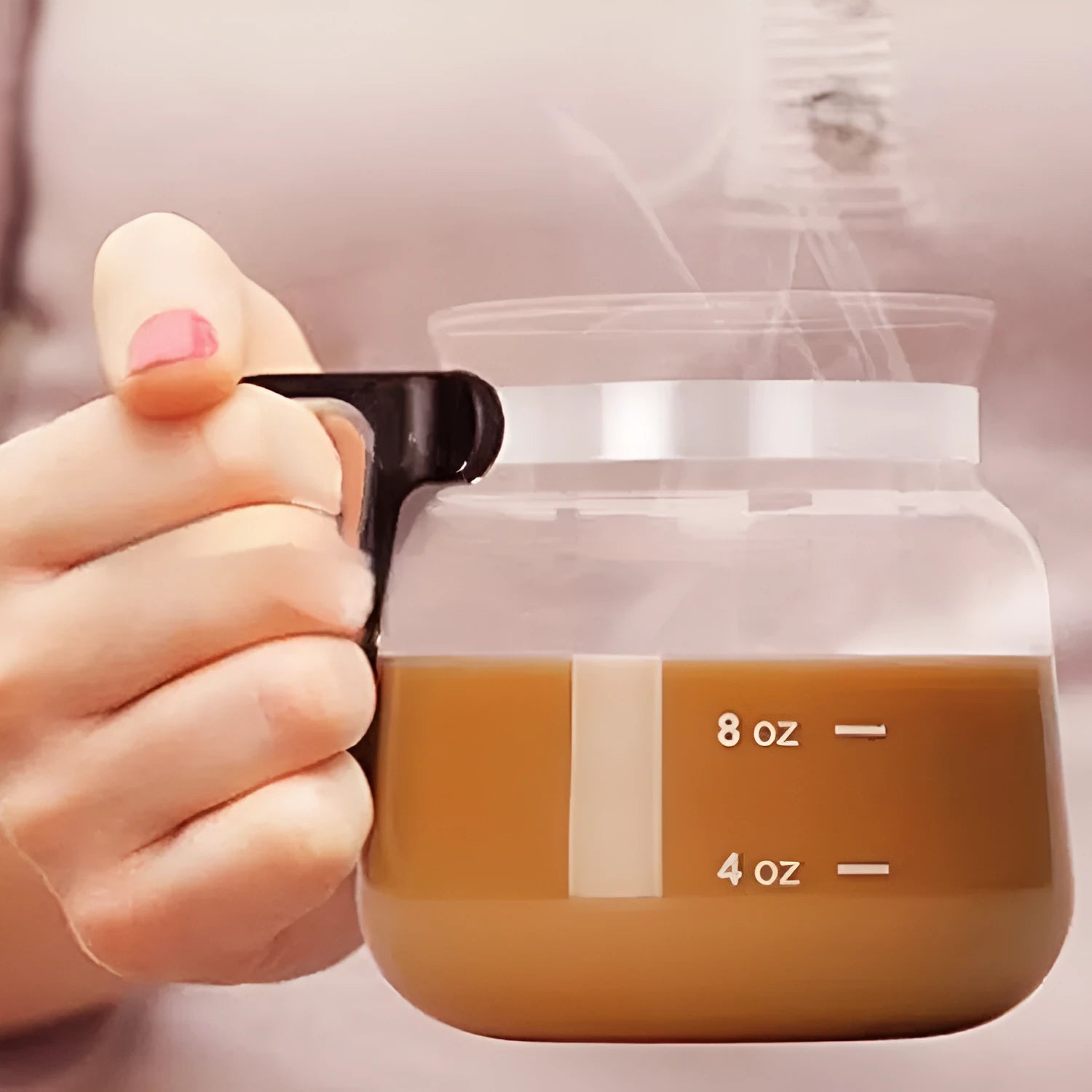 Transparent borosilicate glass coffee maker with a black silicone cover on its lid.