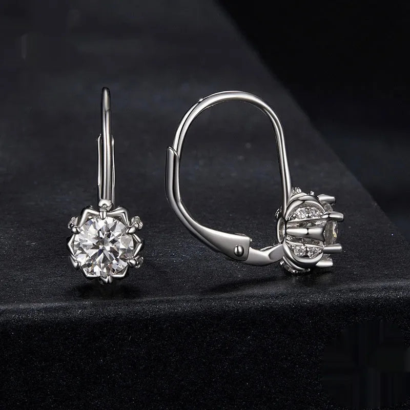 Close-up of a sterling silver flower bud ear clip with a white gold plated finish and a central moissanite stone.