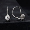 Close-up of a sterling silver flower bud ear clip with a white gold plated finish and a central moissanite stone.