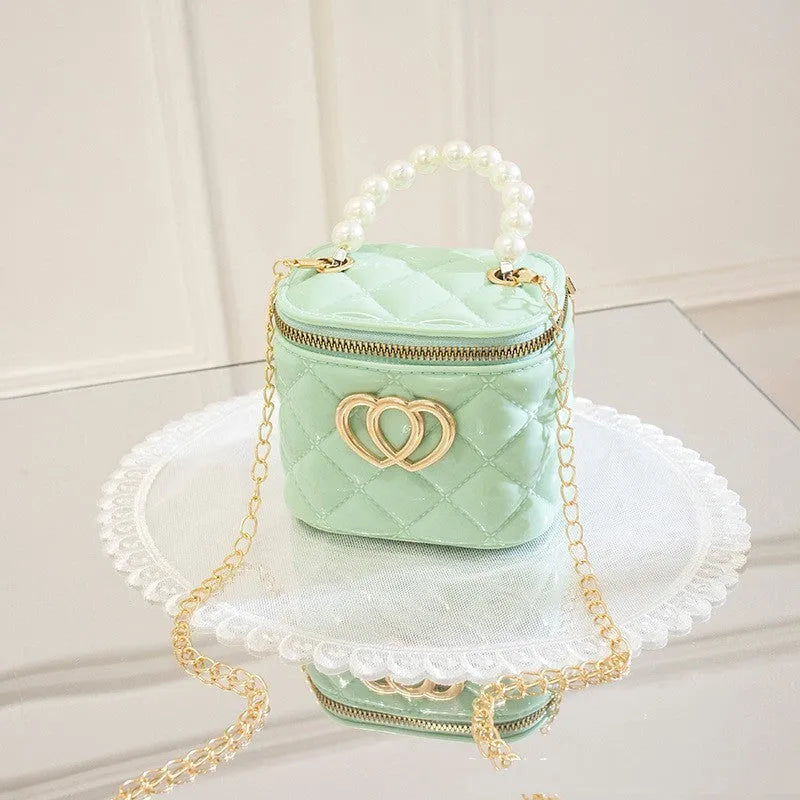 White PVC bucket-shaped cosmetic bag with a red heart pattern, zipper open.