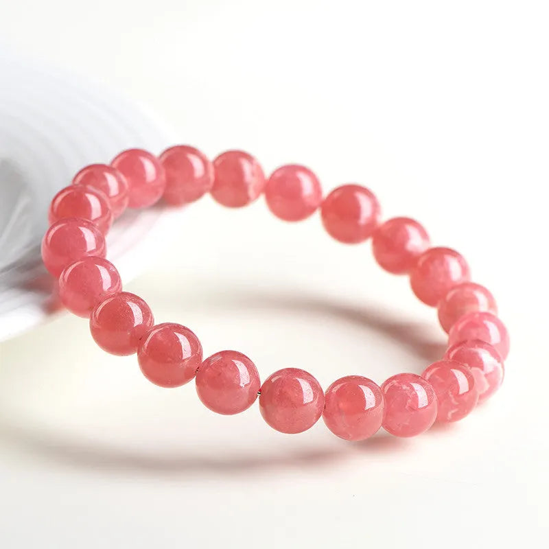 Women's red rhodochrosite crystal bracelet with geometric beads and Longevity Lock element.