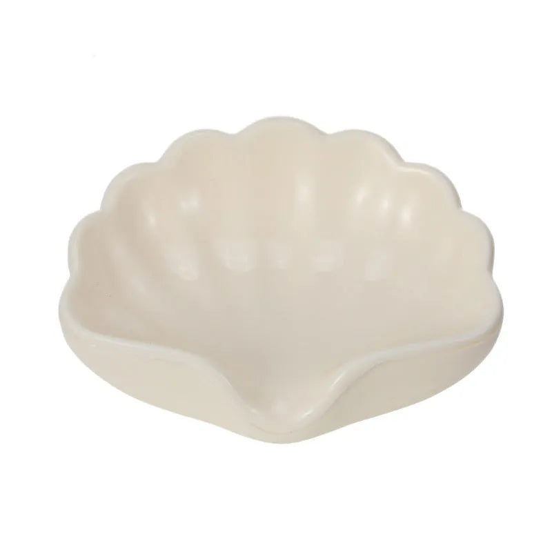 White and pink plastic shell-shaped soap dish for bathroom countertops.