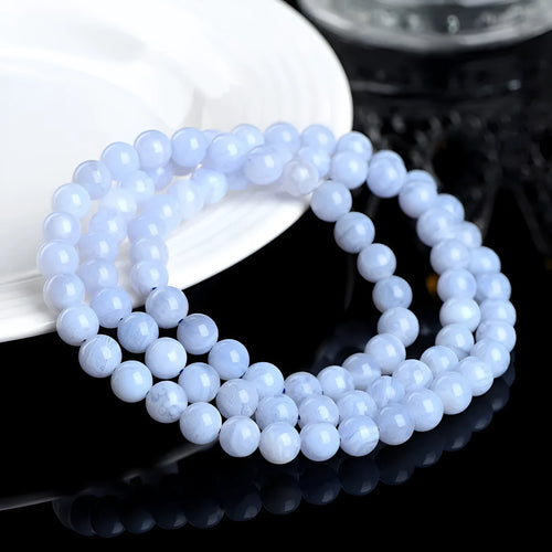 Close-up of a blue agate bracelet with multi-circle patterns, striped beads, and a Ruyi element on a neutral background.