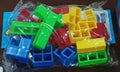 Plastic balance stacking game with 16 colourful building blocks, chassis, and base on a table.