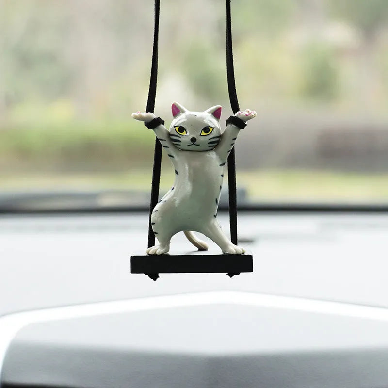 Cartoon-style resin cat pendant on a rope hanger for car interior decoration.