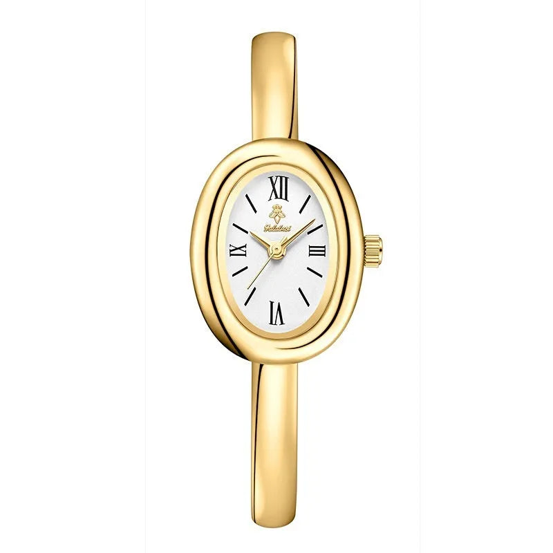 Women's gold and silver oval retro quartz watch with spiral pattern dial on wrist.