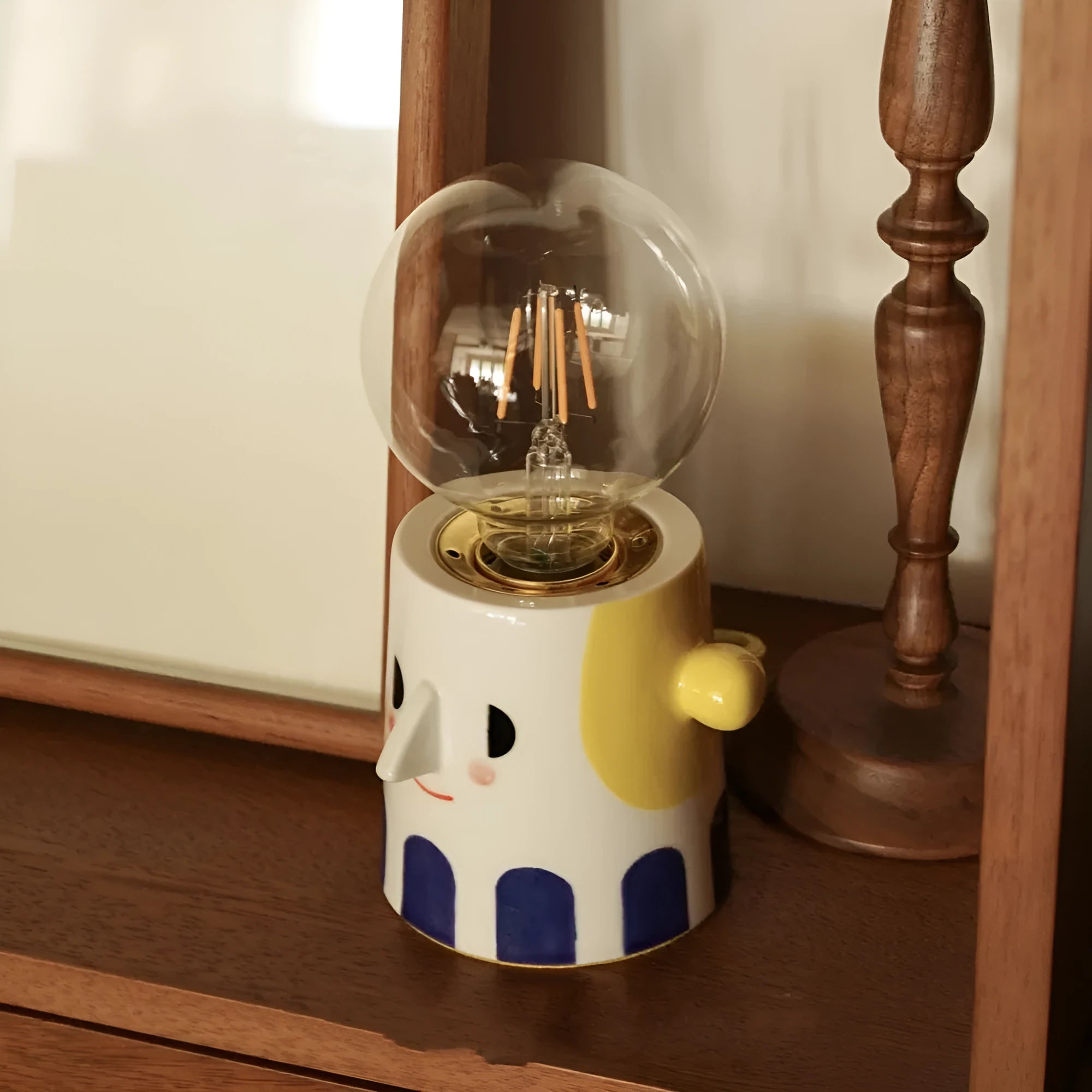 Handmade ceramic table lamp with ball headlight design on bedside table