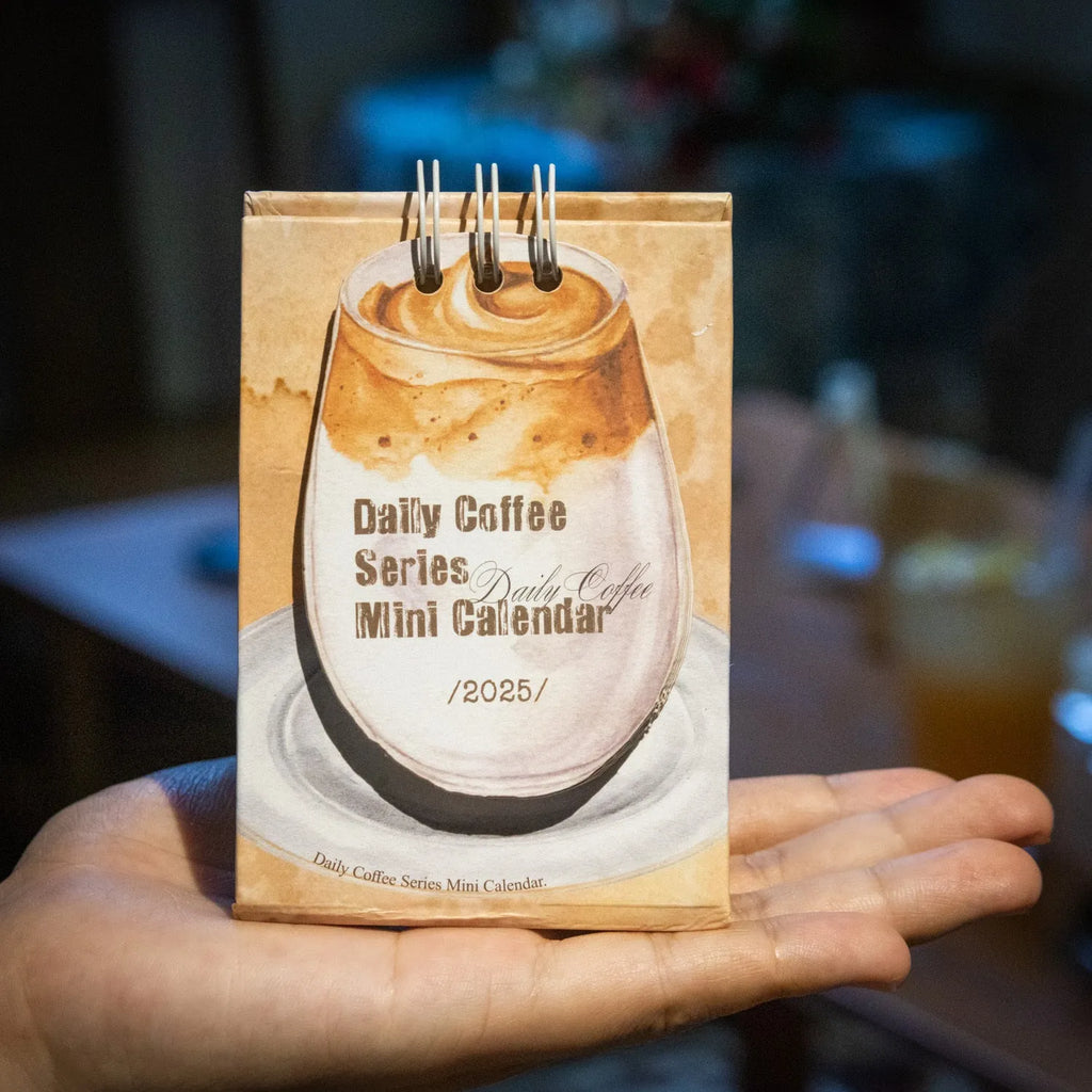 Coffee themed mini desk calendar for 2025 showing four different model designs on a desk.