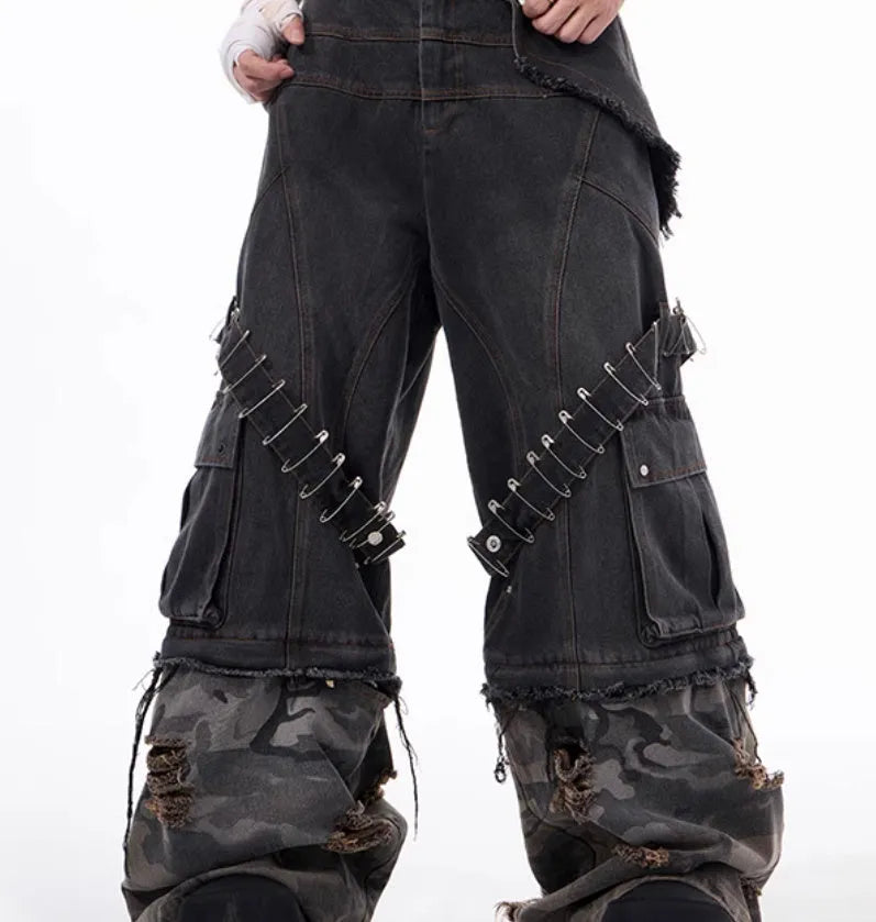 Men's grey camouflage pattern jeans with spliced panels and decorative pin details.