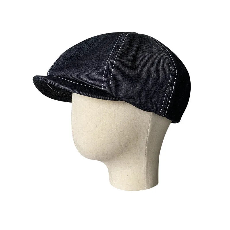 Black cotton beret with an octagonal cap style on a neutral background.