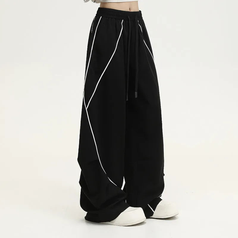 Black pleated wide-leg trousers with stripe pattern showing loose fit and mid waist design