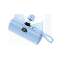 Compact capsule-shaped digital display power bank with integrated USB plug, shown in multiple colours.