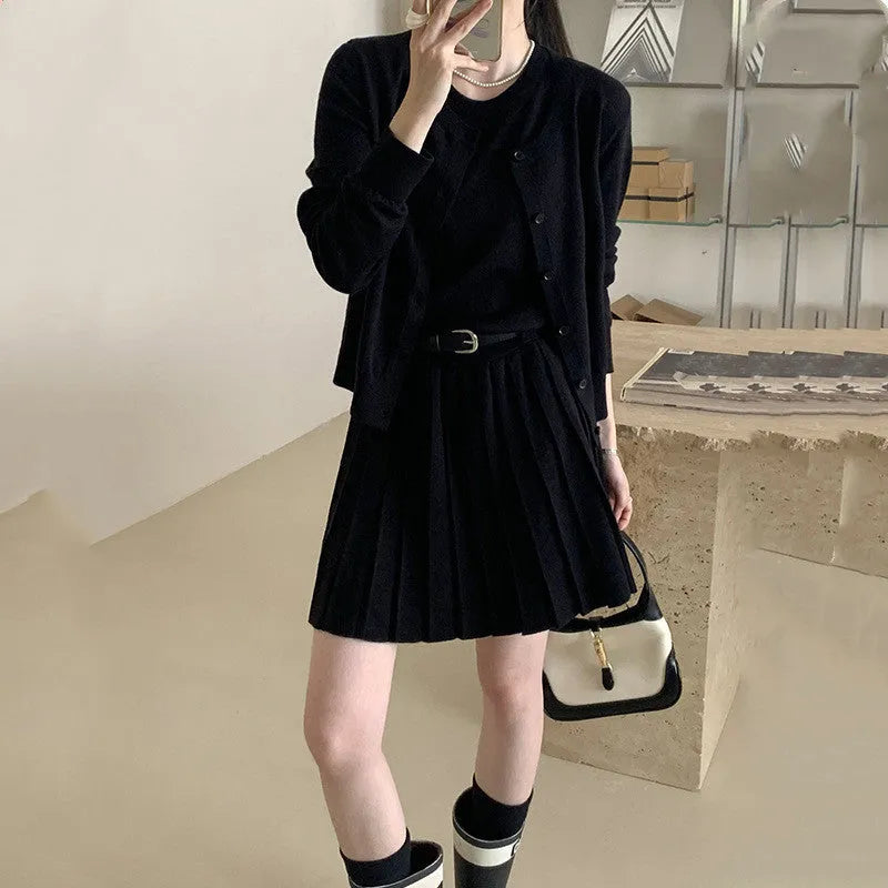 Women's black art retro knitted vest skirt and long sleeve cardigan two-piece set with belt.