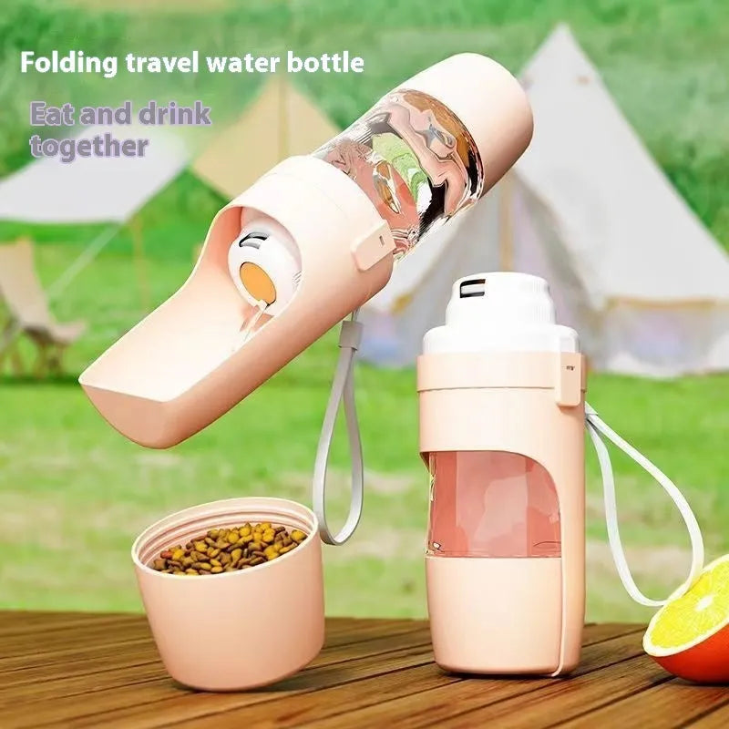 Grey folding travel dog water bottle with attached lanyard and separate food container, shown next to a backpack.