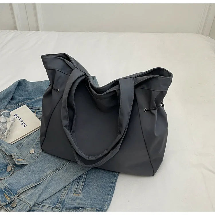 Soft Oxford cloth foldable tote bag shown in one of five colours: black, brown, dark grey, light grey, or purple.