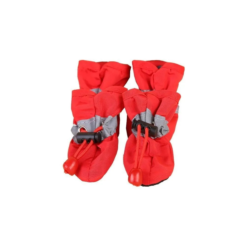 Set of four cloth dog shoes with soft soles in assorted colours on a neutral background