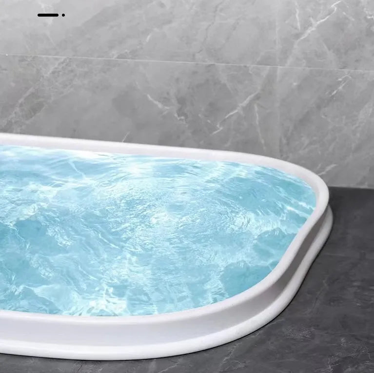 Flexible TPE bathroom water blocking strip in black on white tile floor