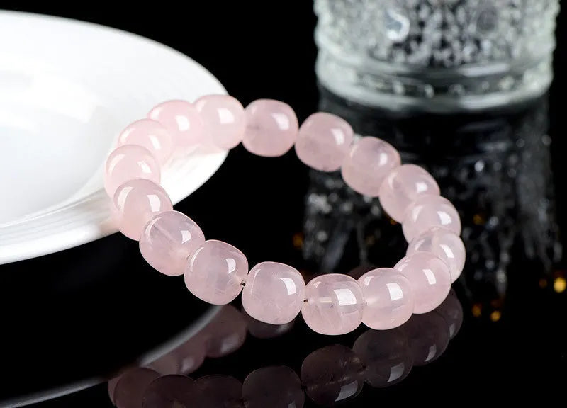 Close-up of a pink crystal barrel bead bracelet with 11-12mm beads on a wrist.