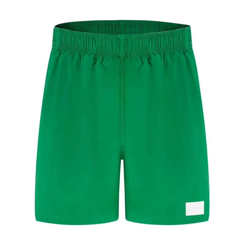 Men's solid colour quick-drying nylon beach shorts on a hanger, showing straight leg opening.