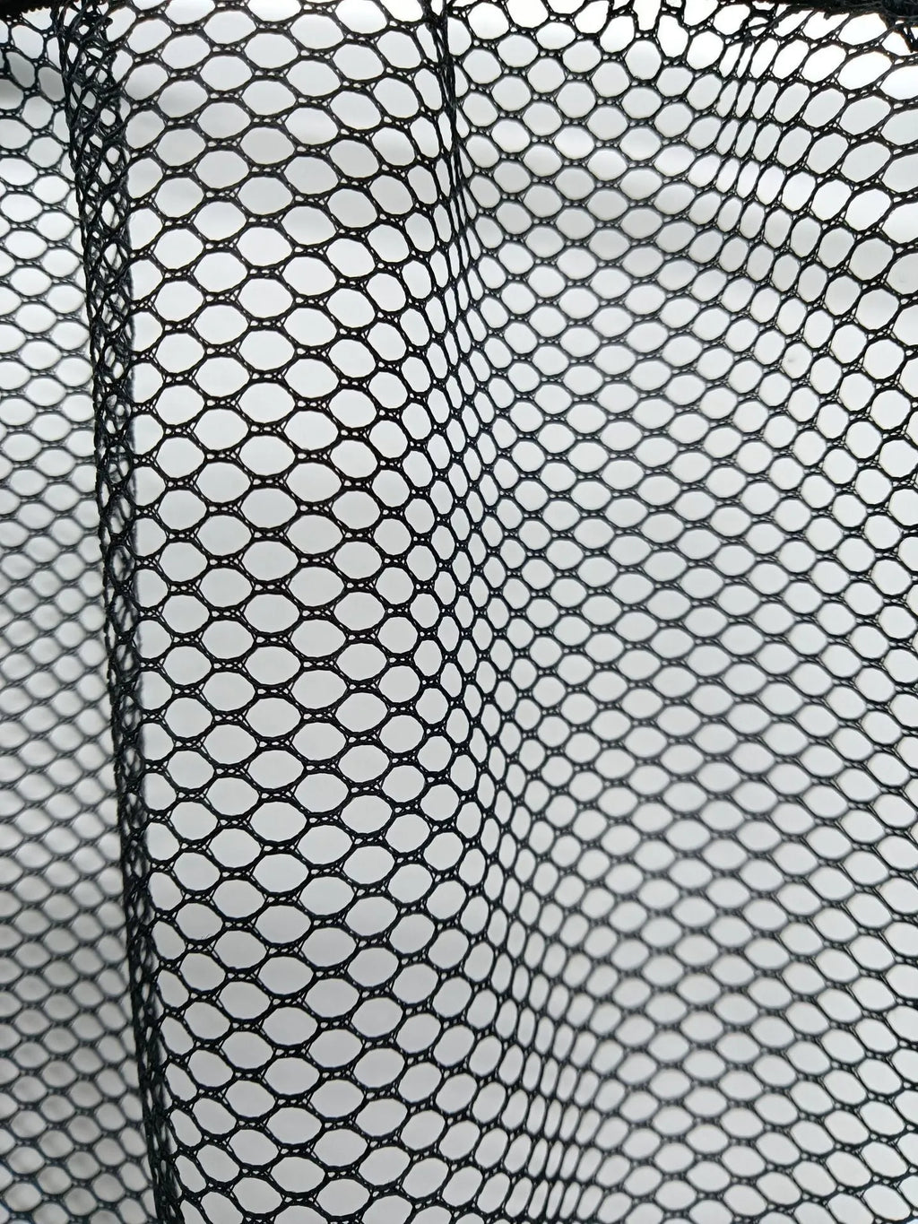 Black elastic polyester storage net for car boot organisation with hook-and-loop fasteners.