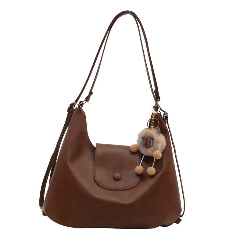 Women's black PU leather single shoulder bag with horizontal square shape and optional pendant attachment