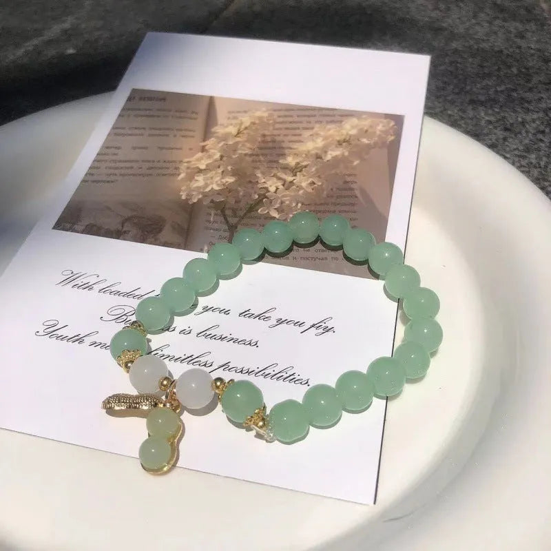 Chinese style handmade glass bead bracelet with bamboo joint elements on a white background.