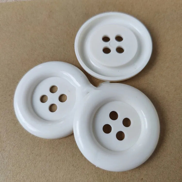 Oversized round plastic nylon button with four holes in various colours and sizes