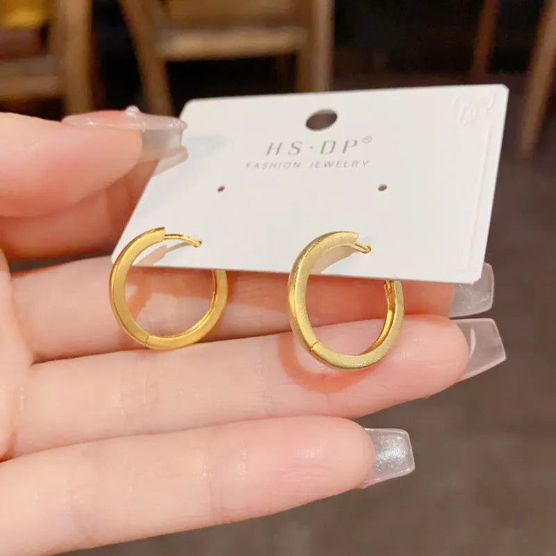 Geometric women's ear clip with real gold plating in gold colour showing round eyelet design