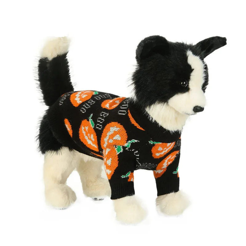 Black dog sweater with a large orange Halloween pumpkin pattern on the back, laid flat.